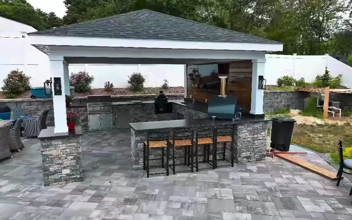 Completed outdoor kitchen with stone counters and built-in cooking area